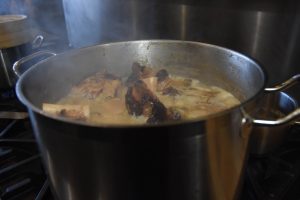 Flower + Bone – Beef bones simmering in large pot on top of stove